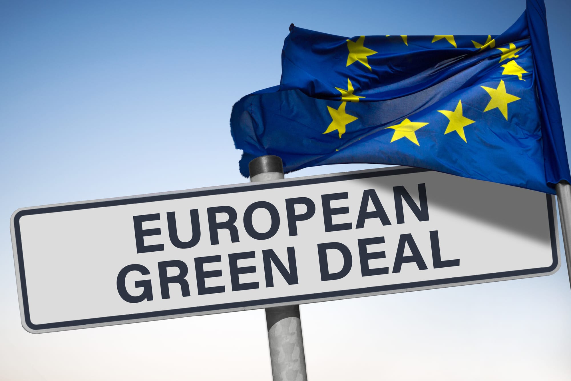 A sign reads "European green deal" with an EU flag waving in front of it